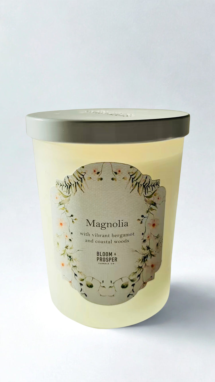Magnolia Candle with a decorative label on a light gray background