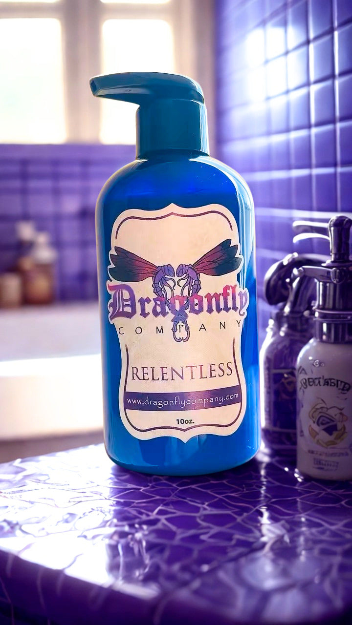 Blue bottle labeled 'Dragonfly Company Relentless body lotion on a purple tiled surface.