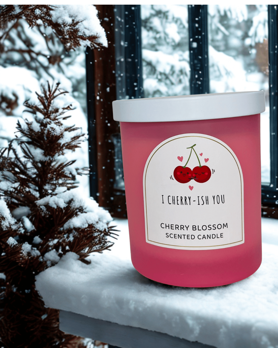 Pink candle labeled 'I Cherry-ish You' in a snowy outdoor setting