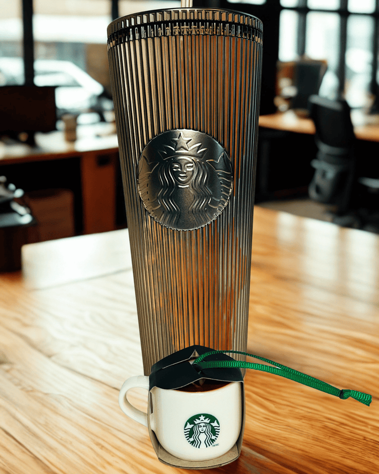 Starbucks tumbler with lid on a wooden table in an office setting and ornament