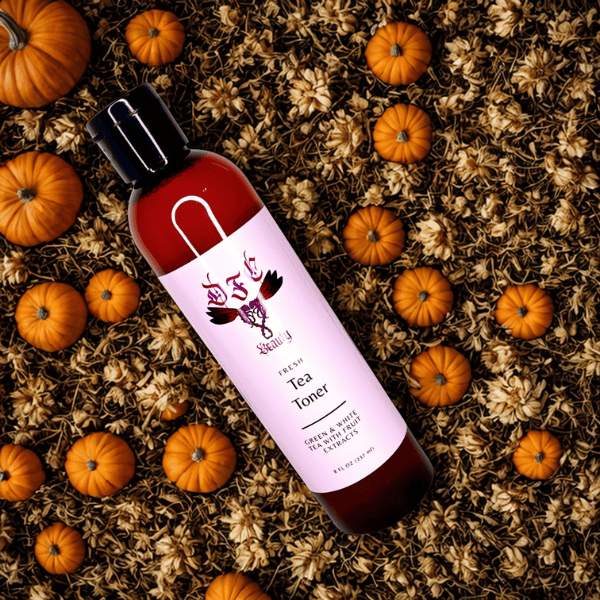 Bottle of tea toner with a pink label on a background of pumpkins and dried leaves