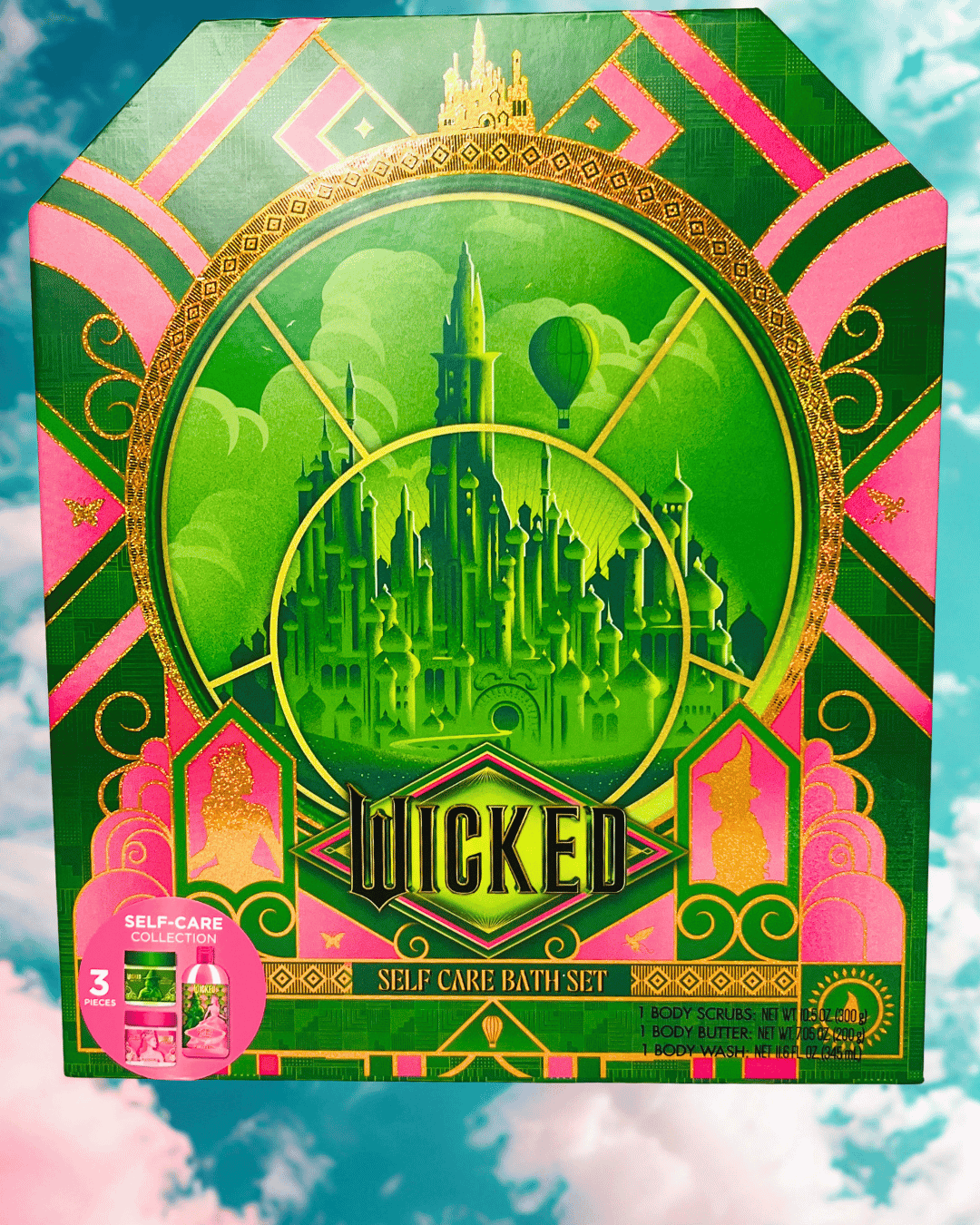 Front of Wicked three piece self-care bath set packaging with green and pink design on a blue and pink cloud background