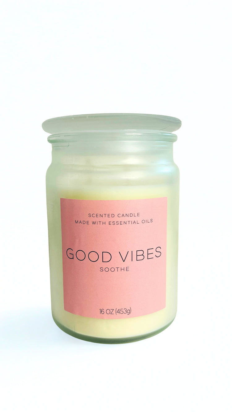 Candle in a jar with a pink label reading 'Good Vibes Soothe' on a white background