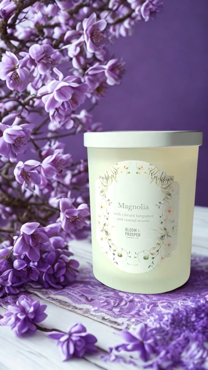 Candle labeled 'Magnolia' with purple flowers in the background