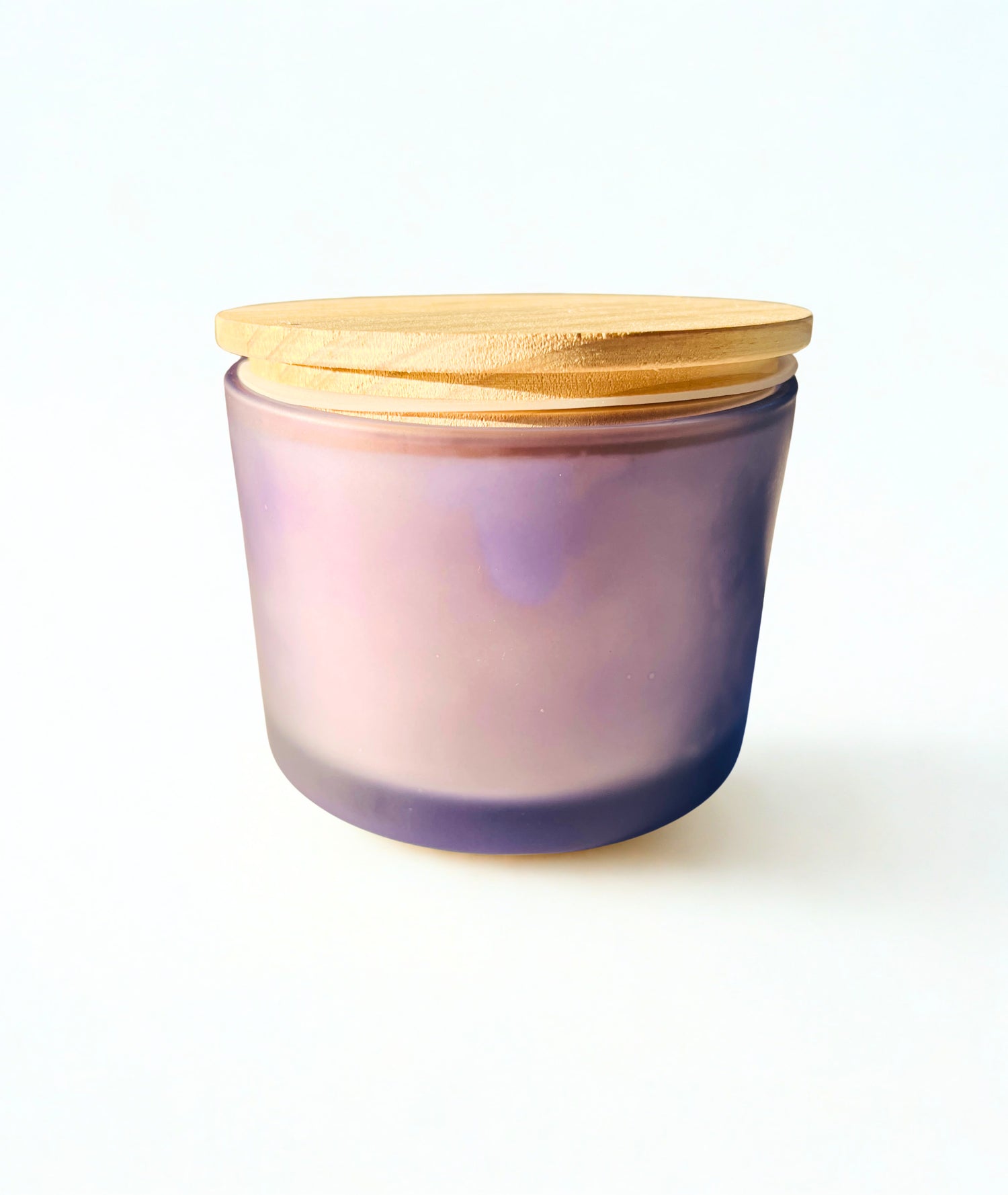 A frosted glass jar candle with a lavender-to-purple gradient and a light natural bamboo lid, set against a plain white background.