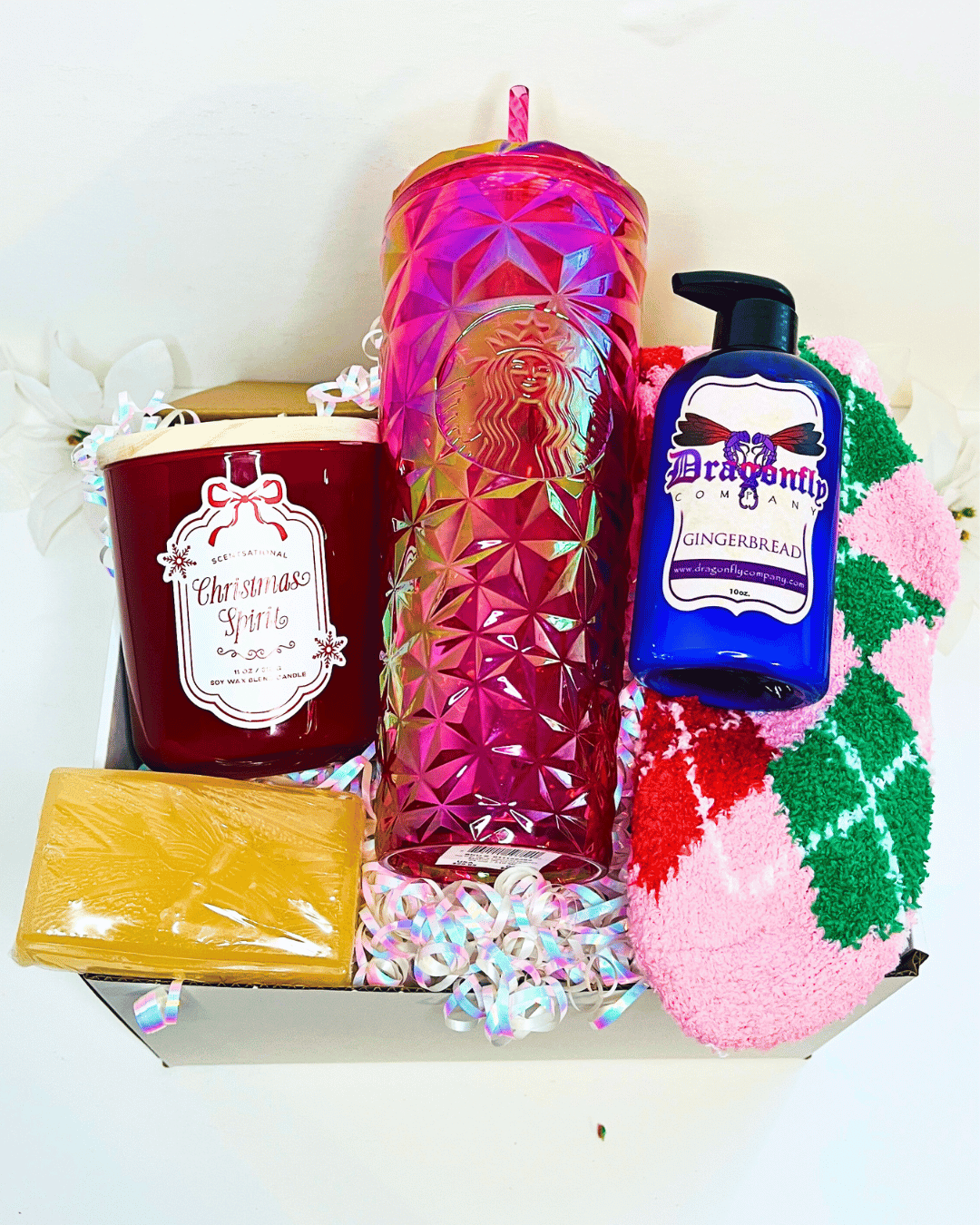 Gift set with a candle, Starbucks tumbler, gingerbread soap, and gingerbread lotion and socks in a box.