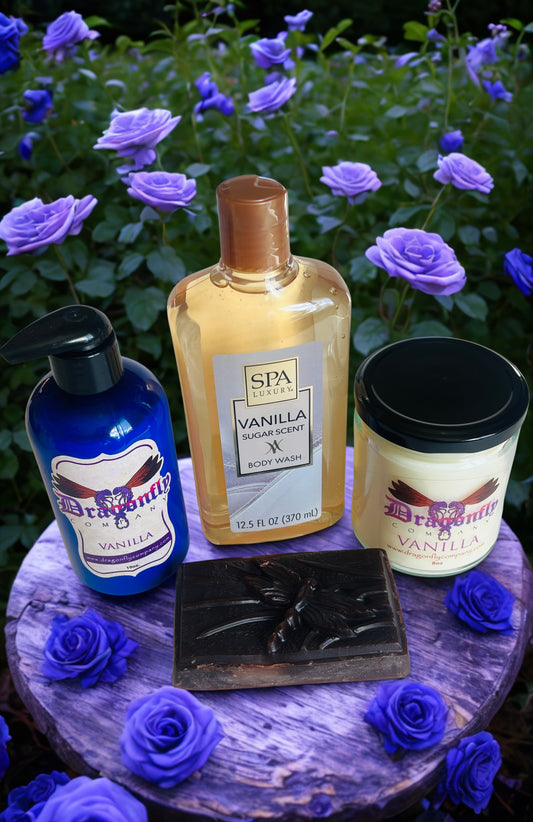 Soap lotion candle body wash and shower puff with purple flowers in the background