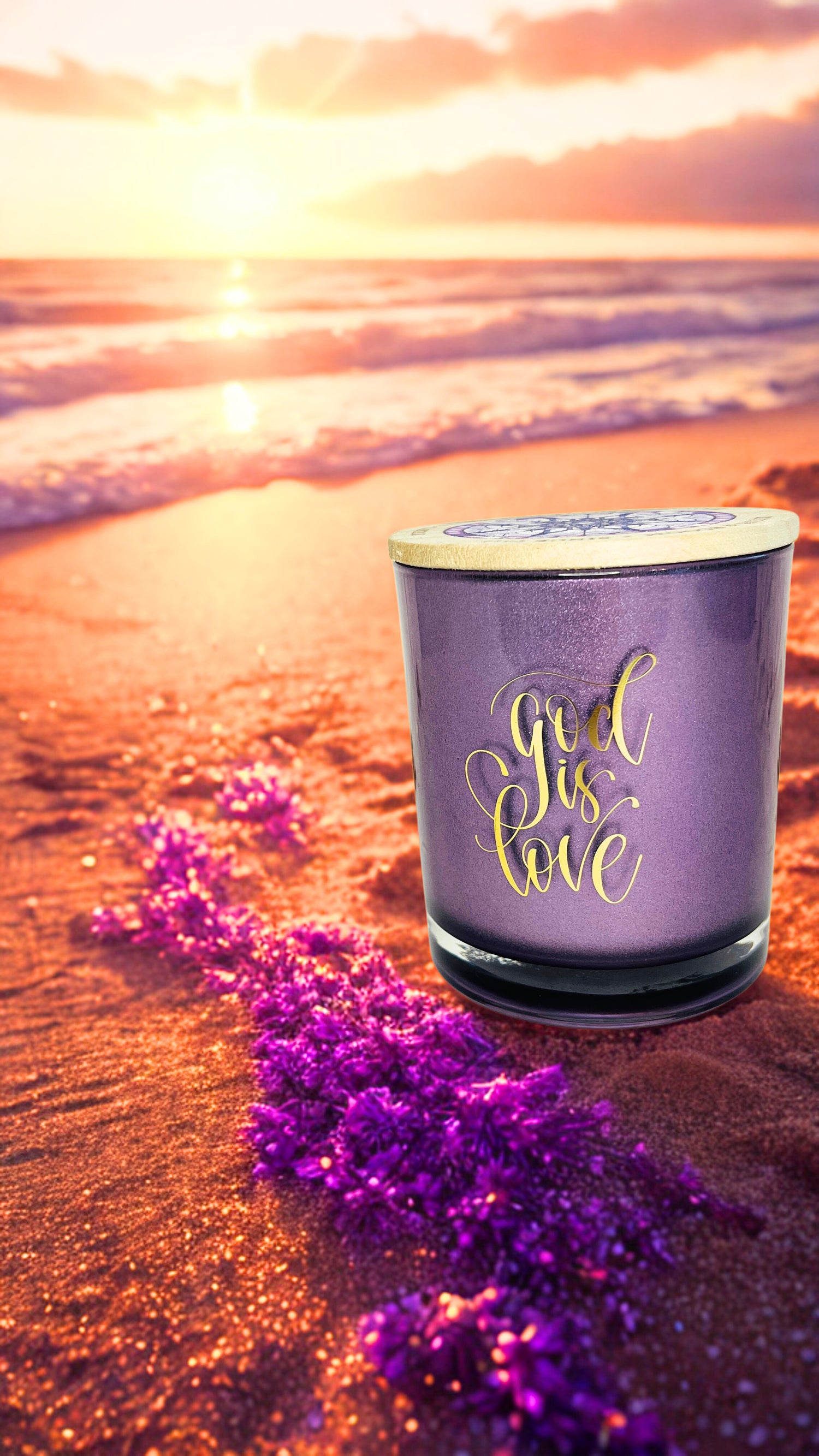 Purple candle with 'God is Love' text on a beach at sunset