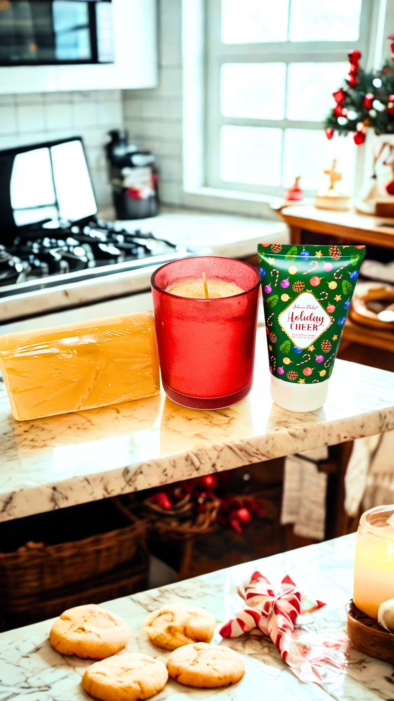 Candle and decorative foot cream and bar of soap on a kitchen counter with a Christmas tree in the background