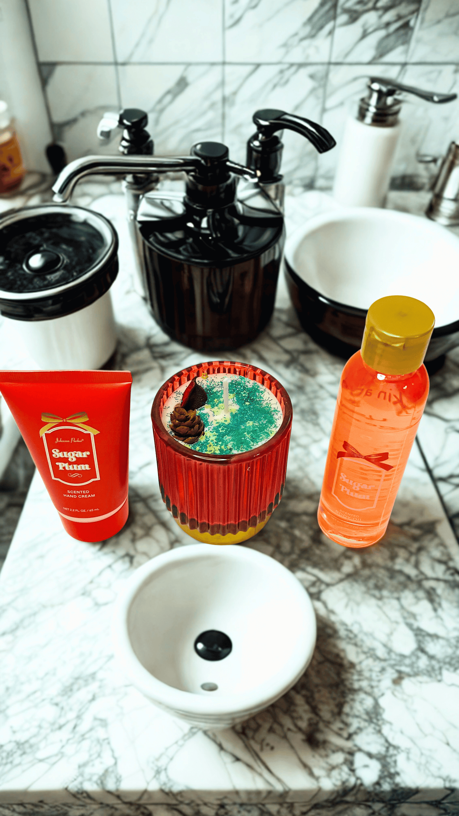 Cosmetic products and candle  on a marble countertop with a sink in the background