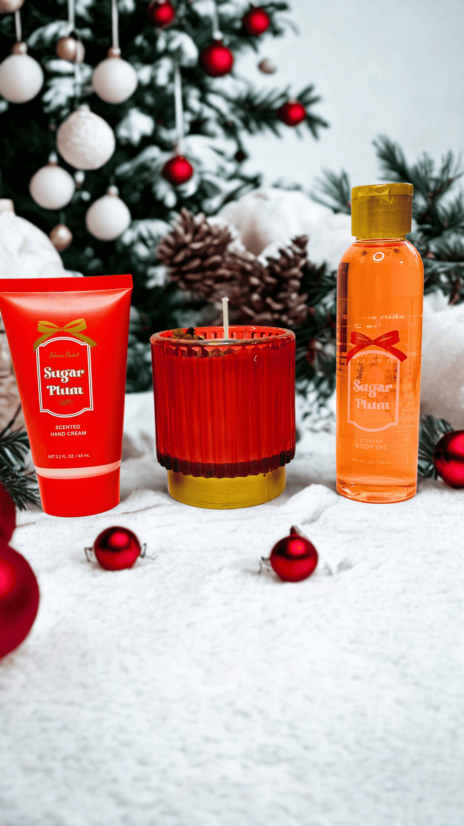 Holiday-themed skincare products and candle with a Christmas tree in the background